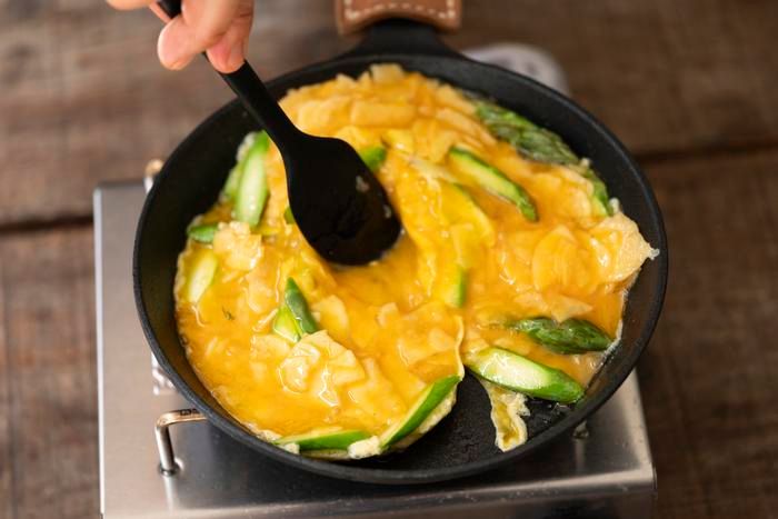 卵とアスパラガスを焼く様子