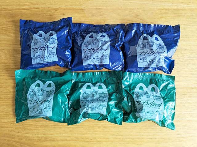 ハッピーセット®「シンカリオン チェンジ ザ ワール」の袋に入ったおもちゃがテーブルに並んでいる様子