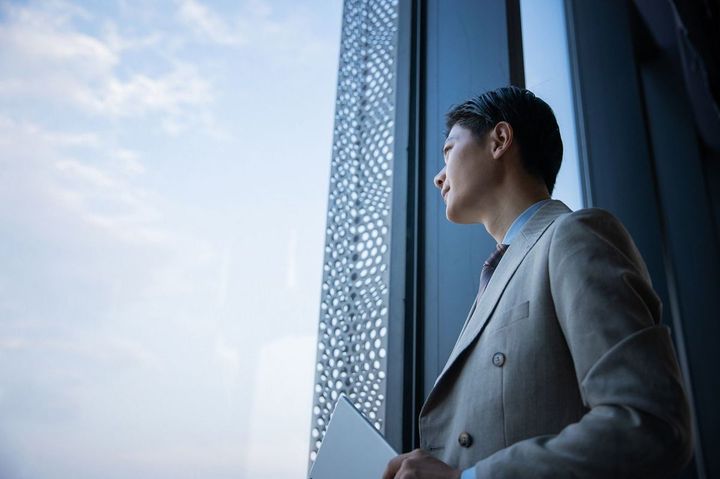 窓から見るビジネスマン