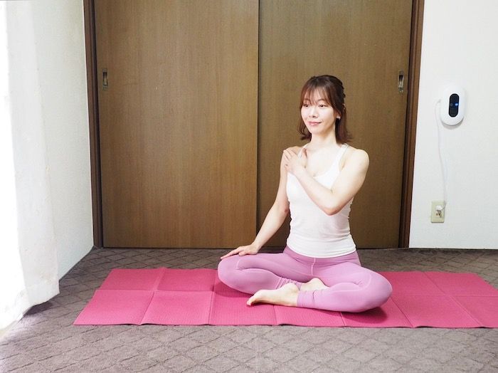 あぐらの姿勢で左手を右肩に添える