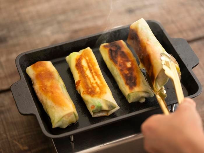 「アスパラガスとチーズとのカニカマの焼き春巻き」を焼いている様子