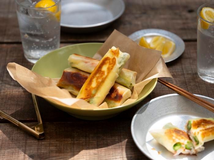 「アスパラガスとチーズとのカニカマの焼き春巻き」とレモンサワーがテーブルに置かれている