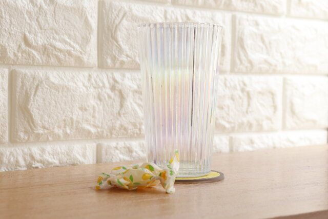 セリアのオーロラグラス ストライプLにドリンクを入れてテーブルの上に置いた様子