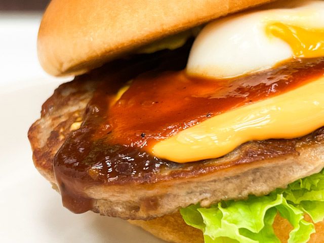 バンズにサンドされた、レタス、パティ、チーズ、照りやきソース、半熟風たまご