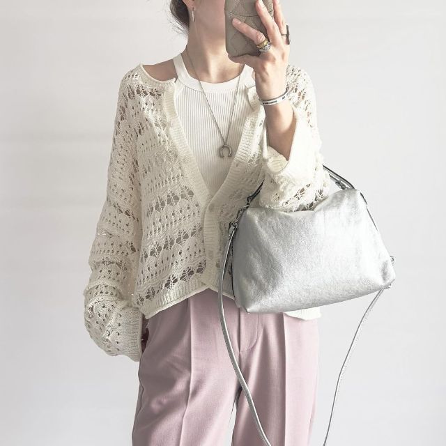 透かし編みカーディガンを着用している