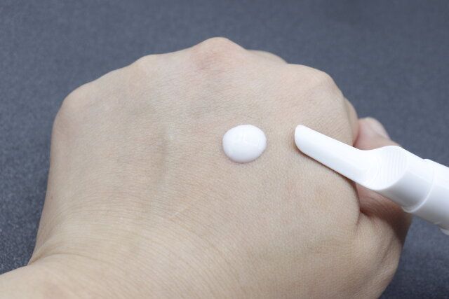 ダイソーのアイクリーム真空容器（長細いタイプ、17mL）で乳液を肌に塗布する様子