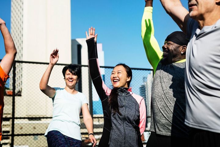 笑顔で手を上げるさまざまな人種の仲間たち