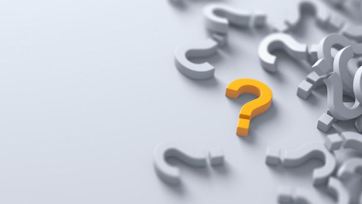 電球が描かれた黒板の前に立つ男性