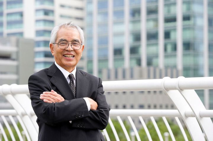 腕を組んで笑顔のシニア男性