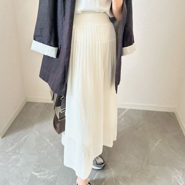 白のGUのシアーニットフレアスカートを着用している