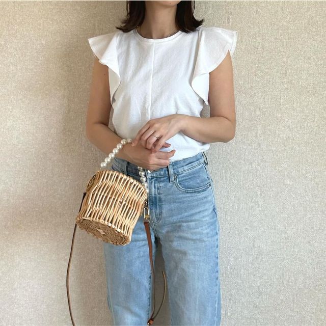 ホワイトのラッフルスリーブTとデニムを着用したコーデ