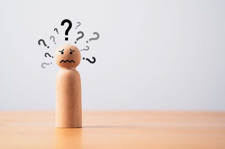 多くのハテナマークを持つ木製の人形