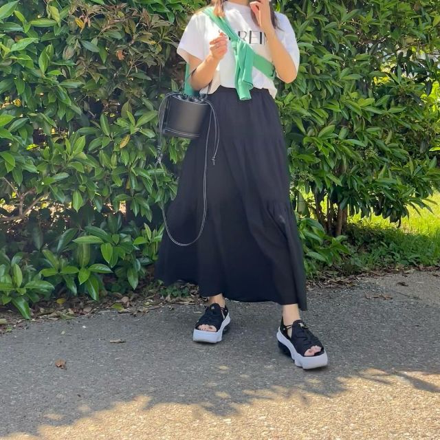 黒のUNIQLOのクリンクルコットンティアードスカートとTシャツとカーディガンを着用したコーデ