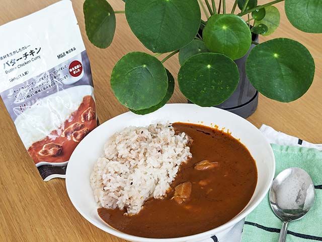 ご飯にかけた「無印良品 素材を生かしたカレー バターチキン」がテーブルに置かれている様子