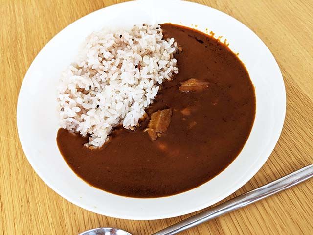 ご飯にかけた無印良品「素材を生かしたカレー バターチキン」がテーブルに置かれている様子