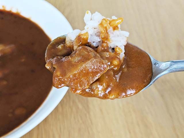 無印良品「素材を生かしたカレー バターチキン」をスプーンですくっている様子
