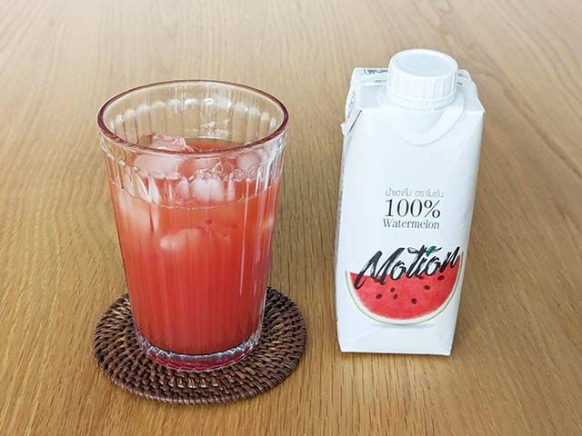 「モーション 100％ ウォーターメロンジュース」がコップに注がれてテーブルに置かれている様子