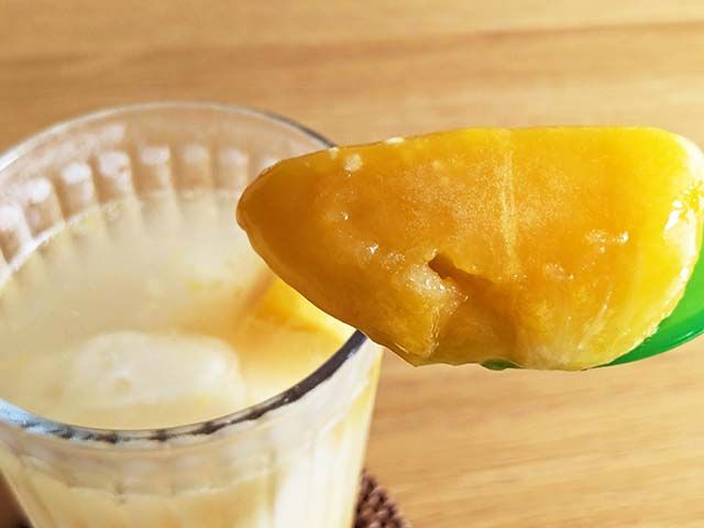 「ドール 完熟マンゴー」をスプーンですくっている様子。トロッと食べ頃。