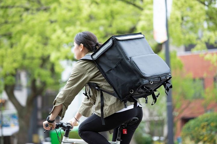 自転車で配達の仕事をする人