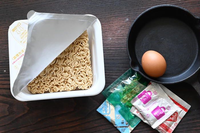 カップ焼きそばとフライパンの上に置かれた卵