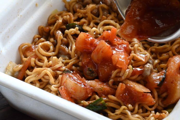 カップ焼きそばにキムチを入れている様子