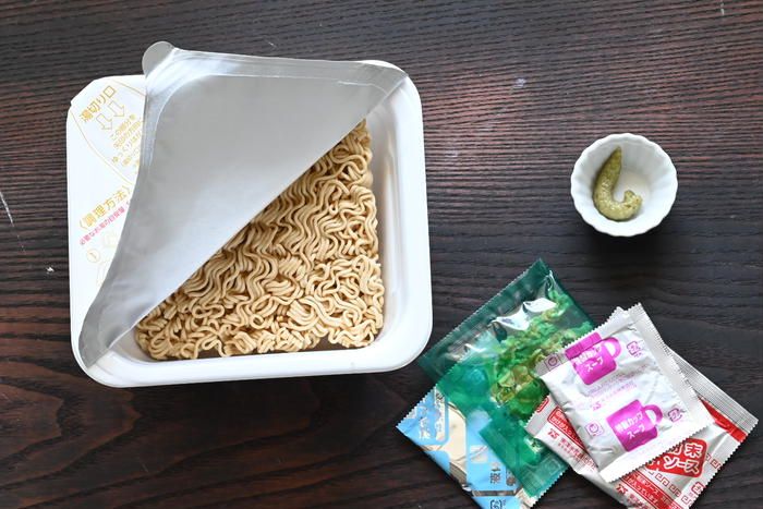 テーブルの上に置かれたカップやきそばと練りわさび