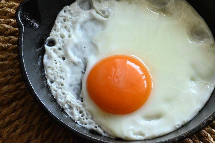 フライパンで調理される目玉焼きの様子