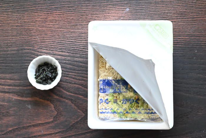 テーブルの上に置かれたカップやきそばと乾燥わかめ