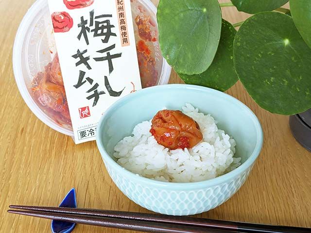 カルディ「梅干しキムチ」と、ご飯の上に「梅干しキムチ」がのったお茶碗がテーブルに並んでいる様子