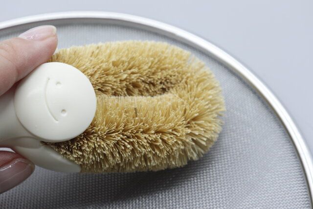 セリアのらくらく立つたわしで網を使っている様子