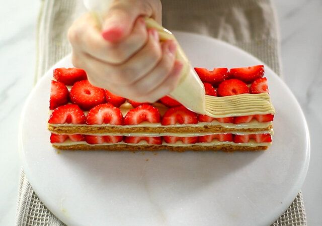 苺の上にカスタードクリームを絞る