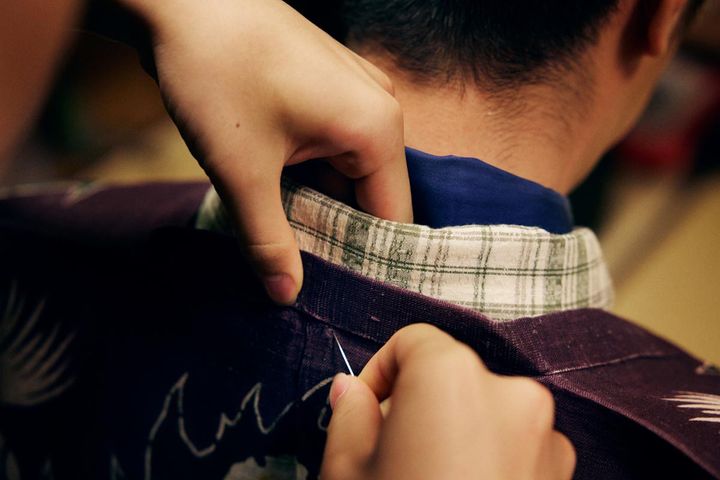 紋付の後ろ襟と綴じ付けていく様子