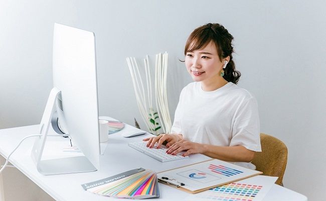 イヤホンで音楽を聴きながら仕事する女性