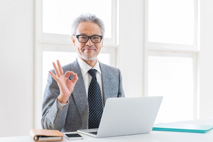 ノートパソコンを使う年配の実業家