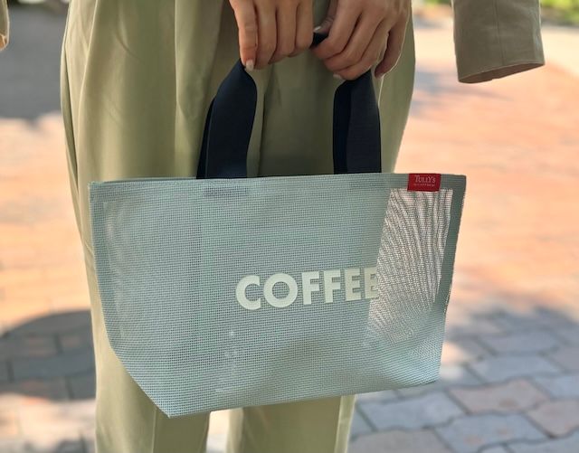 タリーズのメッシュのバッグを手に持ち横から撮影