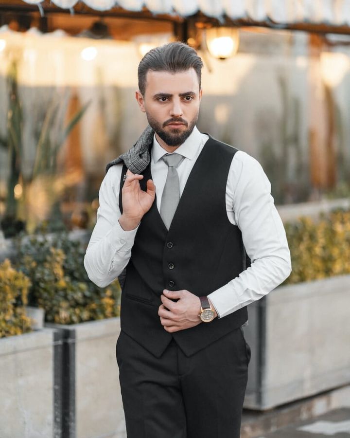 a man in a black vest and tie