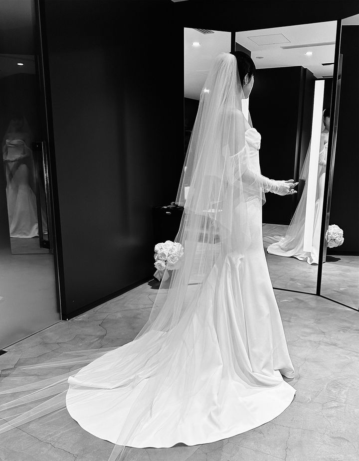 後ろ姿も美しい長めのフェイスアップベール。華美な装飾はないものの、研ぎ澄まされた美しさにセンスが光る。