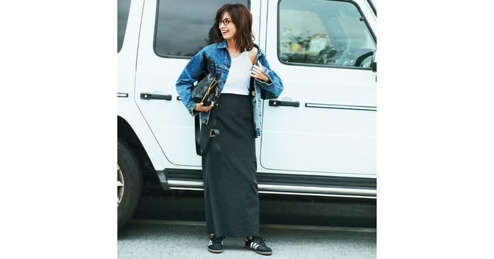 黒タイトスカートに白タンクトップとデニムジャケットを合わせた東原亜希さん
