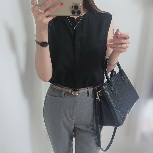 黒のレーヨンスキッパーブラウス/ノースリーブを着用している