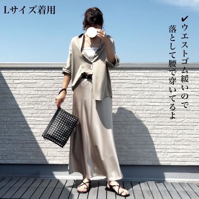 ベージュのサテンスカートを着用している