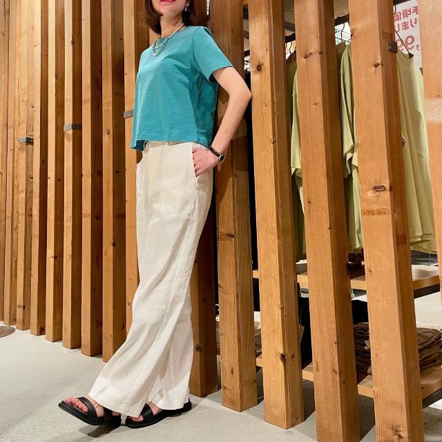 ブルーの半袖Tシャツと白のストレートパンツのコーデ