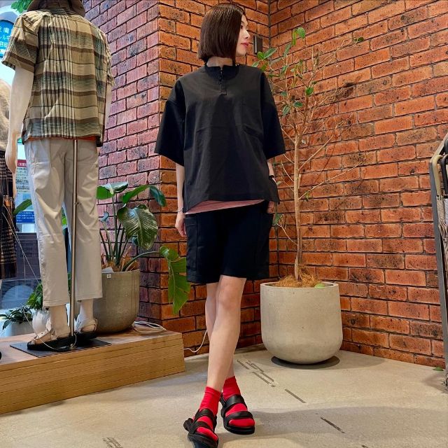 ブラックのTシャツとブラックのショートパンツとピンクのインナーと赤の靴下とブラックのサンダル