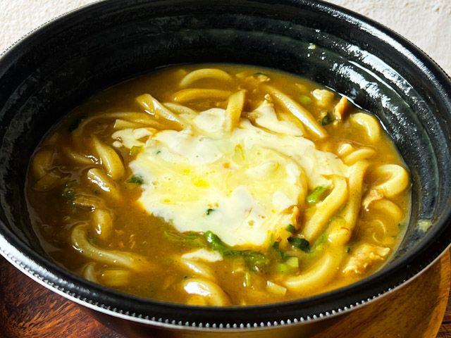 器に入った「ハーフチーズ・ハーフほうれん草カレーうどん」