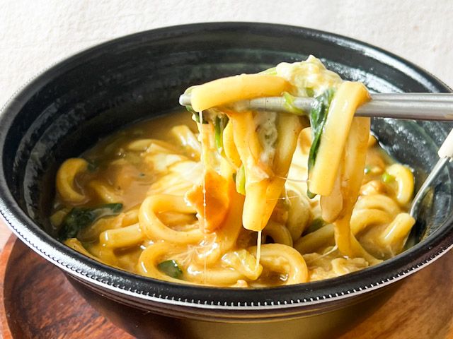 箸で持ち上げた「ハーフチーズ・ハーフほうれん草カレーうどん」