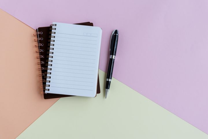 Note pad and pen on colorful pastel colored background