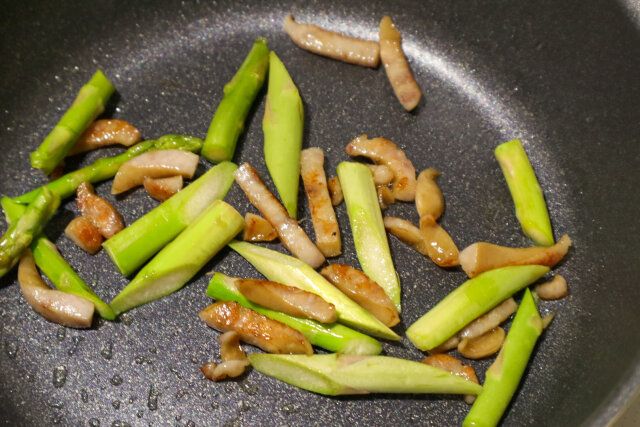 炒めたベーコンにアスパラを加える