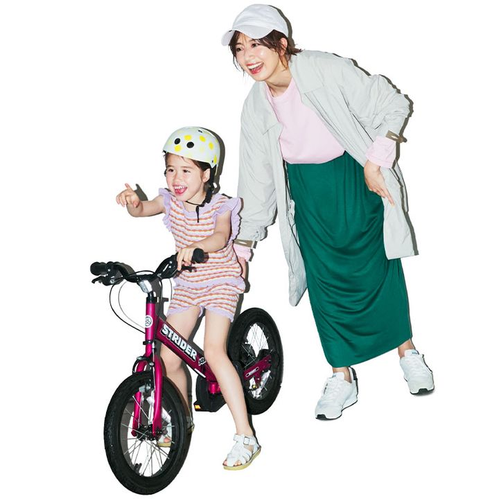 ピンクのTシャツにグリーンのスカート、ベージュのアウターを羽織った公園コーデの東原亜希さん