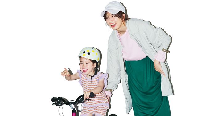 ピンクのTシャツにグリーンのスカート、ベージュのアウターを羽織った公園コーデの東原亜希さん