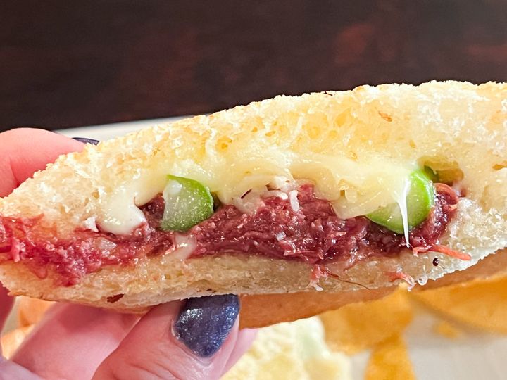 手に持った「アスパラ入コンビーフチーズのホットサンド」