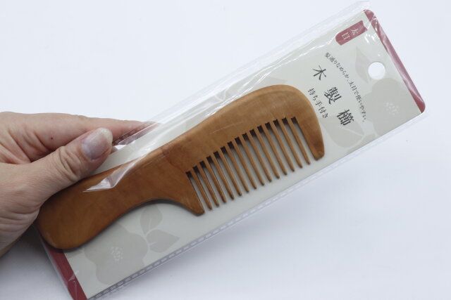 セリアの木製櫛（持ち手付き、太目）を持つ様子